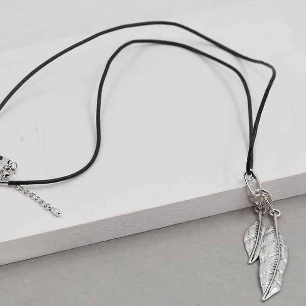 Feather pendant on long black leather necklace