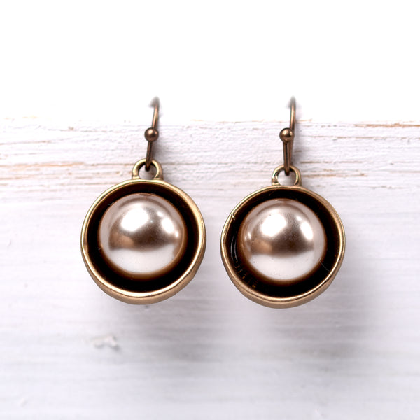 Pearl drop earrings encased in a metal surround