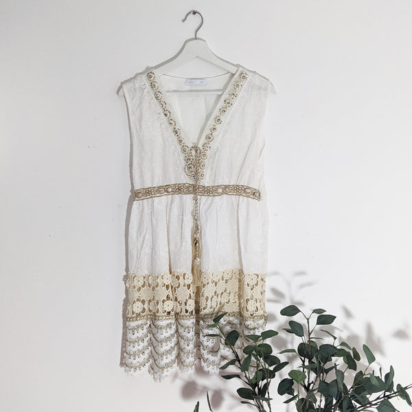 Short sleeveless embroidered cotton dress with gold trim and shell elements