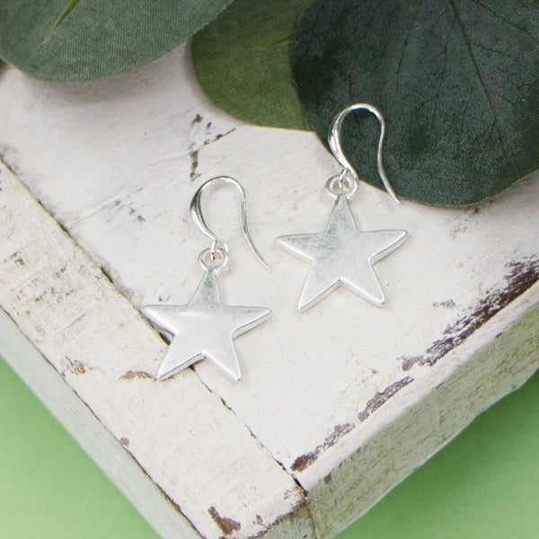 Worn silver stars on fish hook earrings