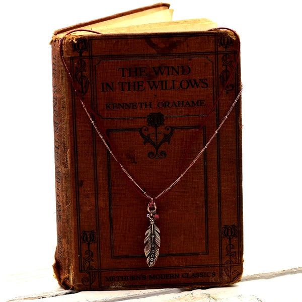 Long feather pendant on delicate short chain with beads